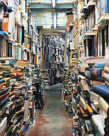 Literatur & Theater Bild: Bücherregale und Bücherstapel