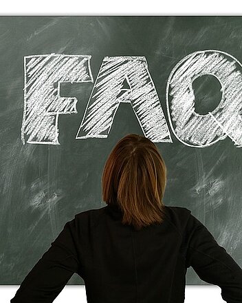 Frau vor Schultafel mit FAQ Aufschrift Bild: Frau vor Schultafel mit FAQ Aufschrift